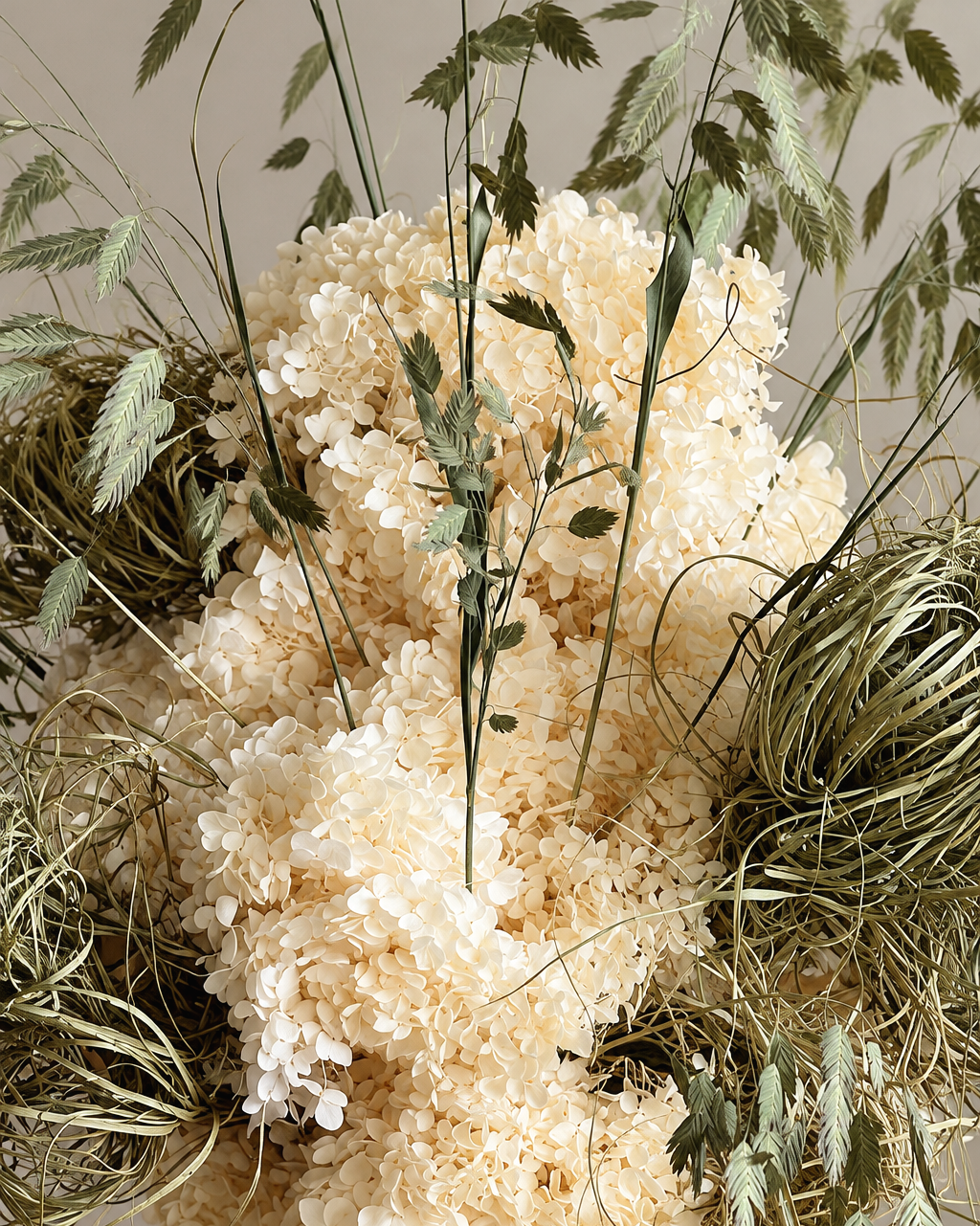 Close-up of cream preserved hydrangea and wild oat grasses in the Ecru centrepiece
