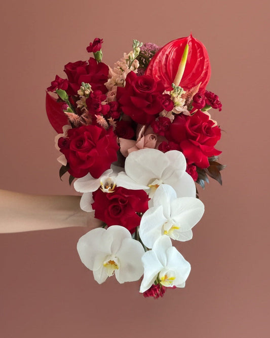Cascading bridal bouquet in burgundy tones with phalaenopsis orchid — The Bridal Edit Hot Cocoa